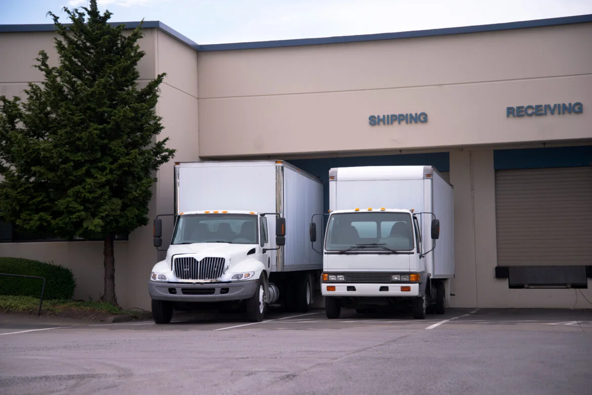 Two middle class semi trucks with box trailers stand in dock on Starting a box truck business